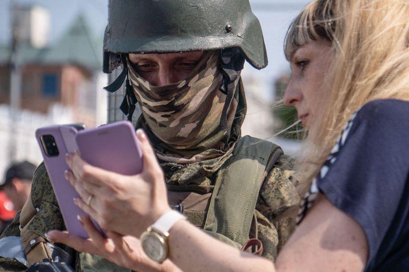 一名俄國婦女讓瓦格納士兵看她的手機。(Getty Images)