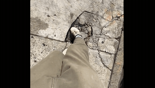 網紅Casey Neistaty用腳試探曼哈頓破碎的人行道，竟然露出洞穴。(截取自TikTok)