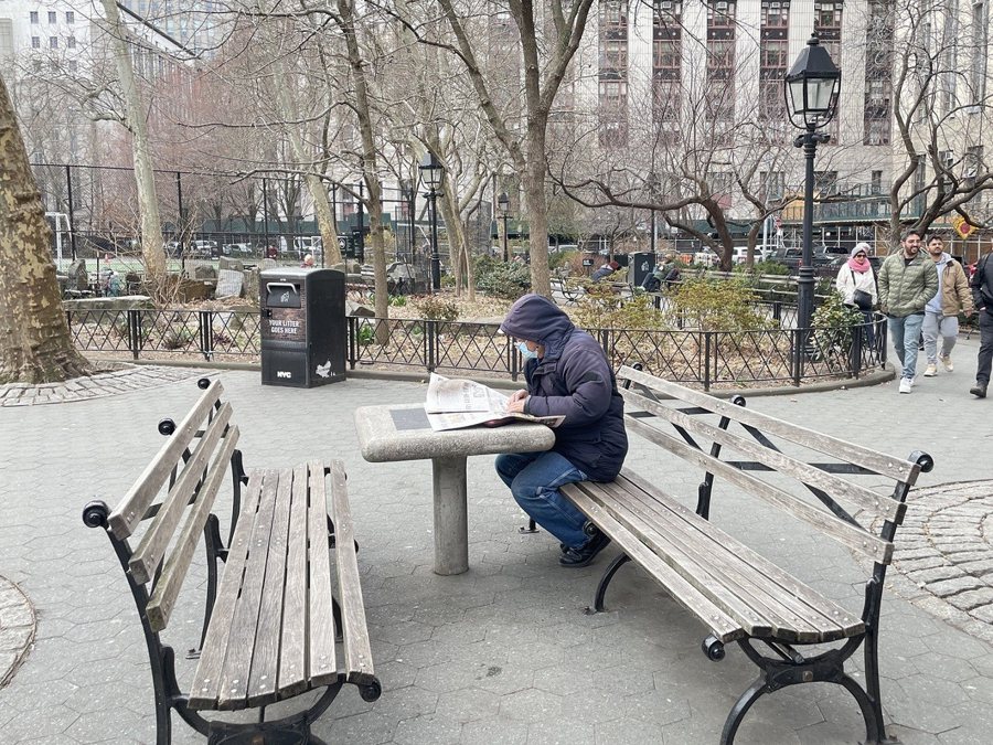 曼哈頓華埠獨自看報的老人。因為子女工作的忙碌，愈來愈多的華裔老人選擇獨居。(記者張心／攝影)
