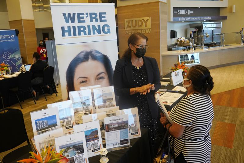 美國上周初次申請失業金者創半世紀以來新低。圖為佛州邁阿密花園一名求職者與雇人單位代表交談。（美聯社）