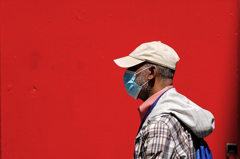 The photo shows a Philadelphia citizen wearing a mask walking down the street.  (The Associated Press)