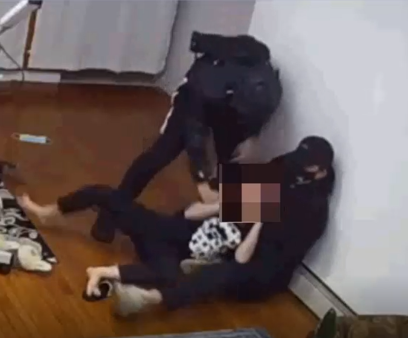 两名男子入室抢劫民宅，把受害人压在地上。 (警方提供)