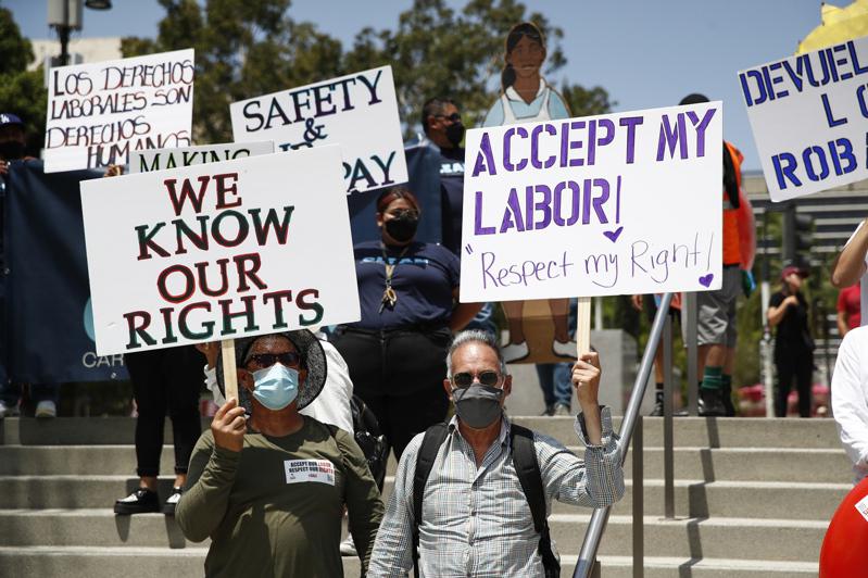 勞動力嚴重短缺，讓工人爭取更好的合約有更多談判籌碼。圖為洛杉磯市移民工人走向街頭...