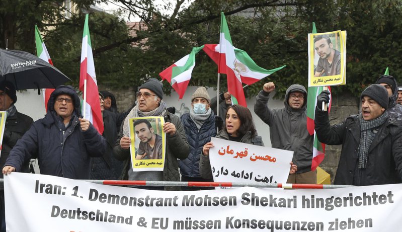 伊朗今天处决一名因伤害巴斯杰民兵组织成员而被定罪的男子谢卡里（Mohsen Shekari），这是伊朗在近3个月头巾革命抗议活动中首度运行死刑。图为民众在德国柏林伊朗大使馆前高举谢卡里照片抗议。美联社