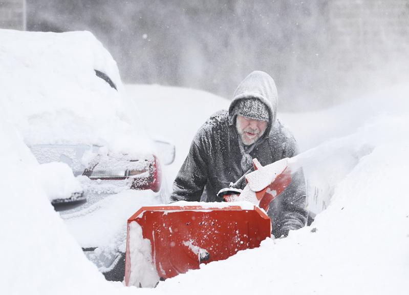 纽约州西部四个郡是受灾最惨的地区，水牛城居民吉朋正在用铲雪机除雪，该区死亡人数已...