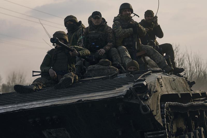 烏東巴赫姆特鎮的烏克蘭士兵，23日坐在一部裝甲運兵車上。(美聯社)