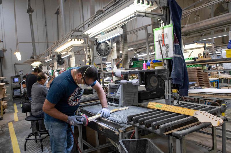 加州一名勞工正在打磨吉他的琴頸，壯年勞工回到就業市場的比率升高。（Getty I...