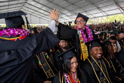 洛州大學生在畢業儀式上擊掌慶祝。（取自CalState LA官網）