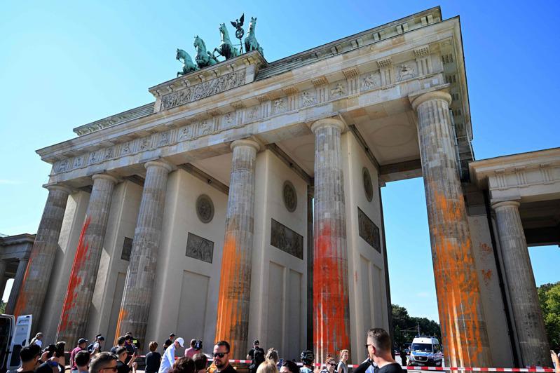 柏林地標布蘭登堡大門的立柱今天被抗議氣候變遷的社運人士噴灑黃色和橙色油漆。他們力促於2030年之前停止使用化石燃料的訴求。（Getty Images）