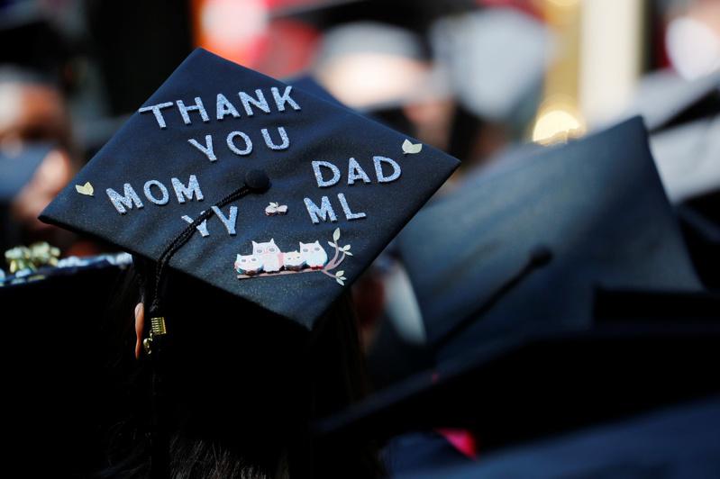 念大學要有投資報酬的考量。圖為一名大學畢業生戴著貼有「謝謝爸媽」字樣的學士帽。(路透)