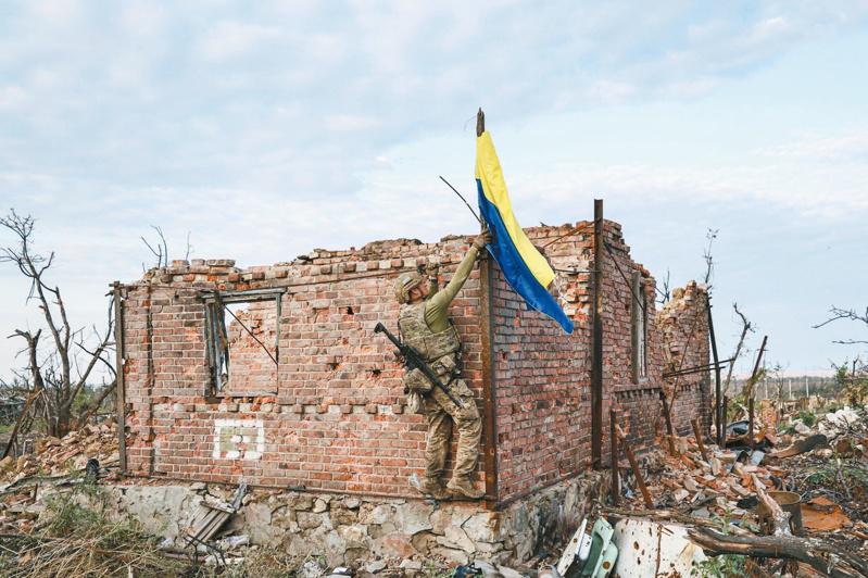 烏軍16日在烏東前線要地巴赫姆特南方約十公里的村莊安德里伊夫卡升起國旗。（美聯社）