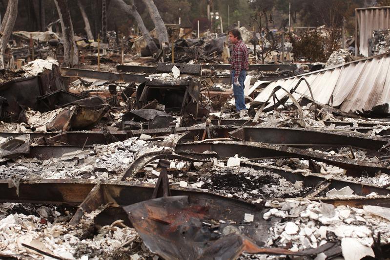 加州議會休會前未能通過山火災害保險相關法案。圖為一位屋主站在被山火焚毀房屋廢墟上。(Getty Images)