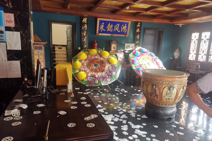 王某在飯店大廳擺放上司的遺像和2個大花圈，還在地上灑滿紙錢。（取材自澎湃新聞／黃浦警方供圖）