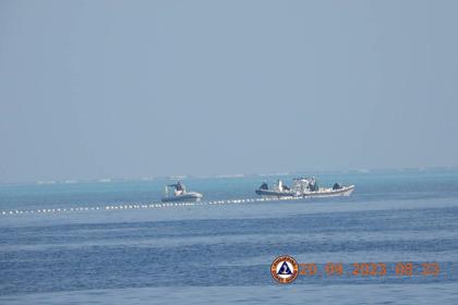 菲律賓海岸防衛隊24日發布照片，顯示中國海警船20日出現在南海黃岩島「漂浮障礙」附近。（路透）
