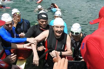 前總統馬英九（中）10度挑戰泳渡日月潭，最後以2小時48分完賽，被攙扶上岸。(記者賴香珊／攝影)