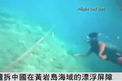 菲律賓派潛水員下海割除中方設置的浮動屏障繩索。（取材自鳳凰網截圖）