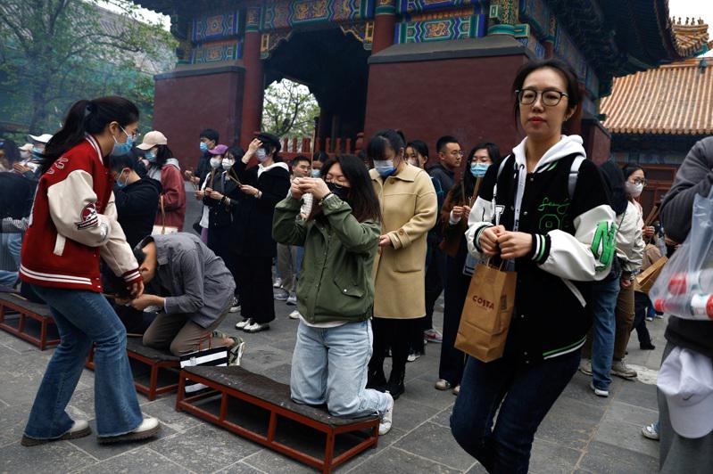 年輕人在北京雍和宮燒香祈求好運。（路透）