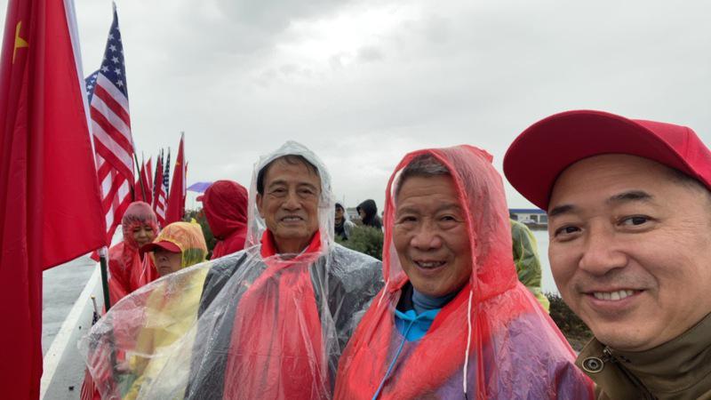 曾文劍（左一）和同行華人，在雨中參加活動。（程章毅提供）